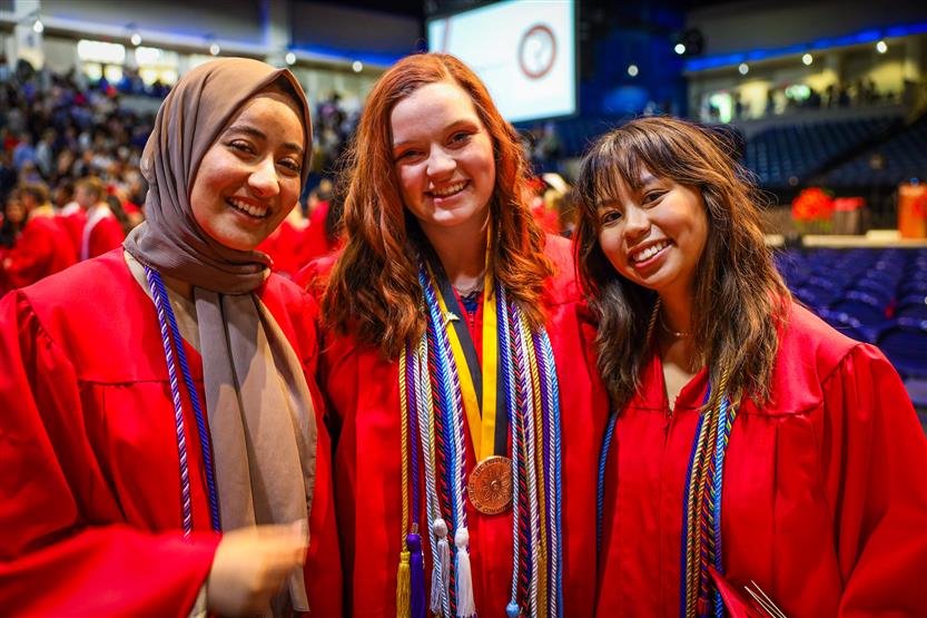 Students in red robes graduate